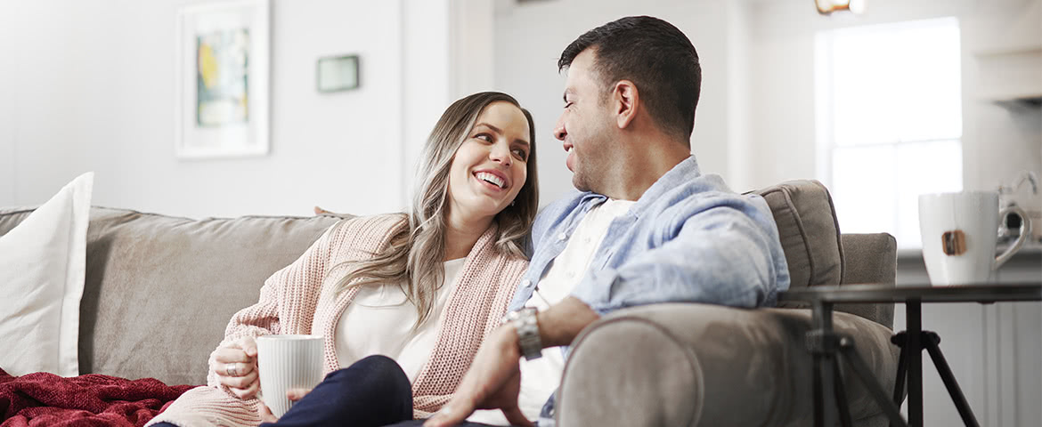 a man and woman drinking coffee on couch